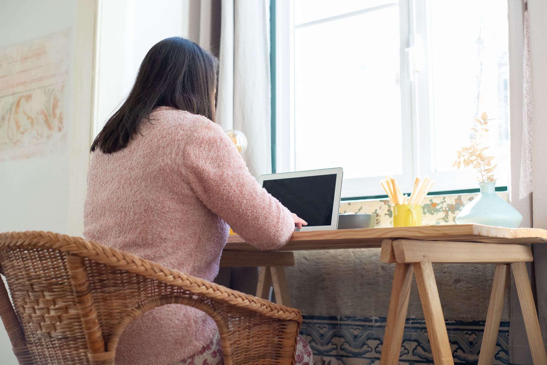 a woman working at home with a laptop